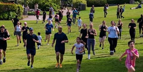 LowFlo members and their families running together across the grass at LowFlo in the Park